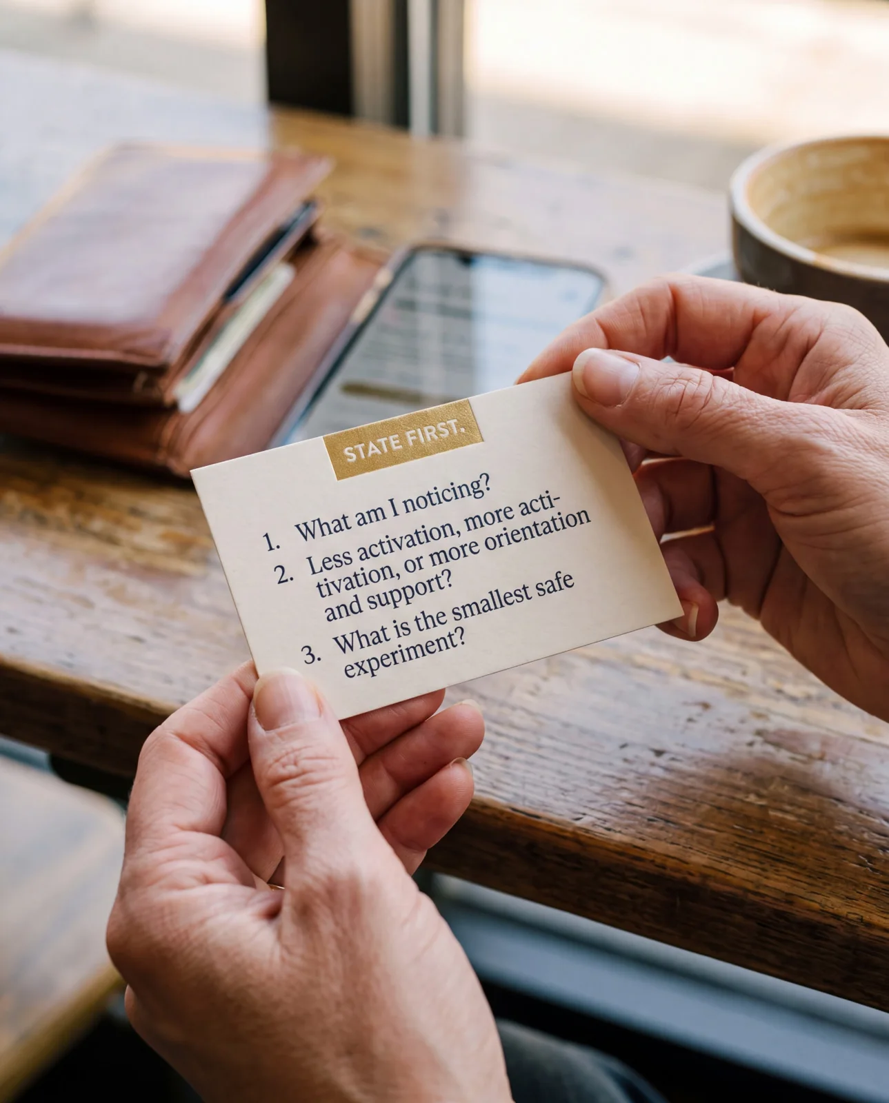 Hands holding the State First three-questions reference card
